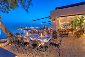 zona de comedor con mesa, sillas y el océano en Glyfada Seabreeze Apartment, en Atenas