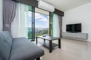 a living room with a couch and a television at Central Hill View 1BR Apartment A940 C in Ban Ket Ho