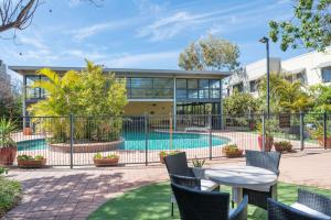 a patio with a table and chairs next to a pool at Rydges Kalgoorlie in Kalgoorlie
