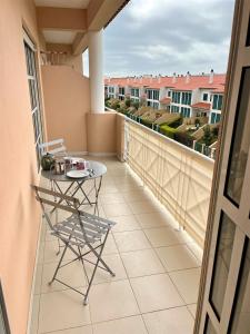 d'un balcon avec une table et une vue sur les bâtiments. dans l'établissement Sun&Zen, à São Martinho do Porto