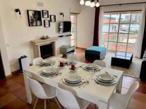 comedor con mesa blanca y sillas blancas en Sun&Zen, en São Martinho do Porto