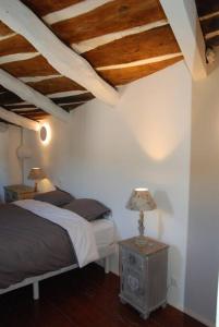 1 dormitorio con 1 cama y 1 mesa con lámpara en grand gîte de charme en Cévennes, en Fressac