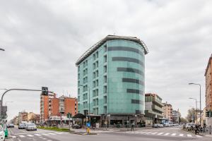 Un alto edificio blu in una strada di città di HOTIDAY Hotel Milano Turro a Milano