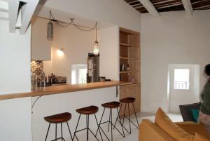 una cucina con bancone e sgabelli in una stanza di grand gîte de charme en Cévennes a Fressac