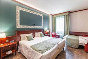 una habitación de hotel con 2 camas y una pared verde en HOTIDAY Hotel Milano Turro en Milán