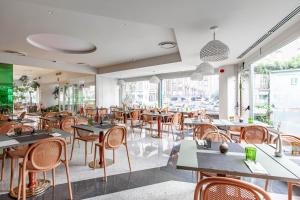 a restaurant with tables and chairs and a large window at HOTIDAY Hotel Milano Turro in Milan