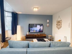 a living room with a blue couch and a flat screen tv at Spacious Apartment -Double and Sofabed -Wonderful Royal Pavilion Views in Brighton & Hove +40 photos