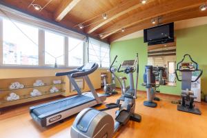 a gym with cardio machines and a flat screen tv at HOTIDAY Hotel Milano Turro in Milan