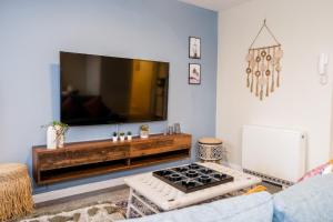 a living room with a flat screen tv on a wall at Spacious Apartment -Double and Sofabed -Wonderful Royal Pavilion Views in Brighton & Hove