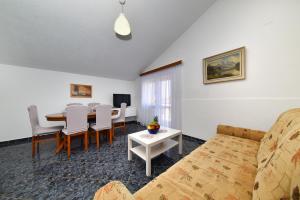a living room with a table and a couch at Apartment Ivo Kaurinovic in Zaton
