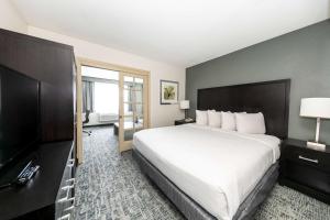 um quarto de hotel com uma cama grande e uma televisão em Best Western Inn & Suites San Diego Zoo -SeaWorld Area em San Diego