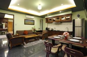 a kitchen and living room with a couch and a refrigerator at Sudee Villa in Rawai Beach