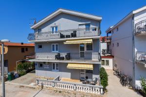 an apartment building with balconies on a street at Apartment Ivo Kaurinovic in Zaton