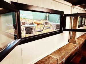 ein Fenster in einem Gebäude mit Blick auf ein Boot in der Unterkunft Alojamiento Camino Portugues in O Porriño
