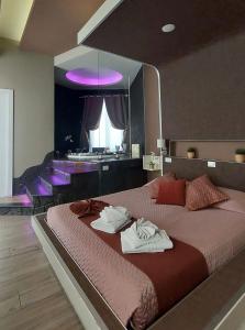 um quarto com uma cama grande e toalhas em Th Luxury em Giardini Naxos