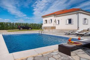 uma villa com piscina em frente a uma casa em Fairyland Villa 150qm für 8pax em Paljuv