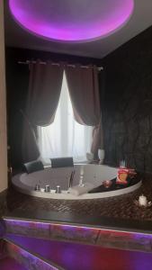 uma banheira com uma luz roxa por cima em Th Luxury em Giardini Naxos