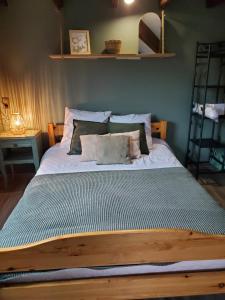 - une chambre avec un grand lit et des oreillers dans l'établissement camping hôtel les airelles, à Saint-Cirgues-en-Montagne
