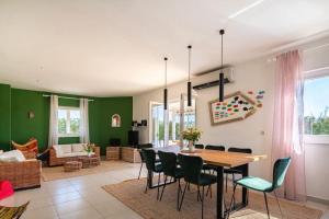 uma sala de jantar e sala de estar com mesa e cadeiras em Fairyland Villa 150qm für 8pax em Paljuv