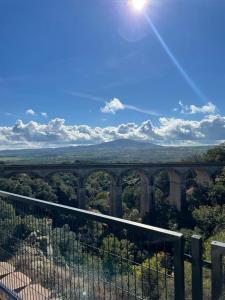 a view of a bridge with the sun in the sky at Mirador del Río in Miraflores de la Sierra