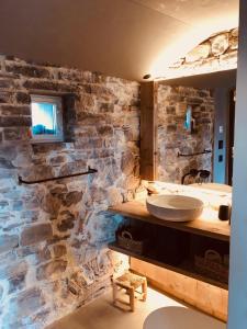 La salle de bains est pourvue d'un mur en pierre et d'un lavabo. dans l'établissement Locanda San Silvestro - Meride, à Mendrisio