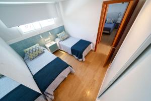 a small room with two beds and a window at Maspalomas Beach Point in San Bartolomé de Tirajana