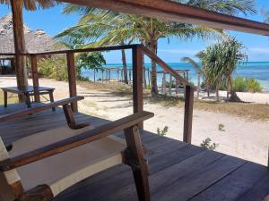 een houten veranda met uitzicht op het strand bij Jaribu Beach Hotel in Paje