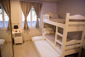 sypialnia z 2 łóżkami piętrowymi i oknem w obiekcie Hospedagem Vila Suiça Centro w mieście Gramado