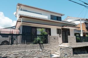 une maison avec une clôture devant elle dans l'établissement MaruHouse, à Nachikatsuura