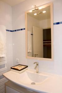 Baño blanco con lavabo y espejo en Short Stay Paris Apartments, en París