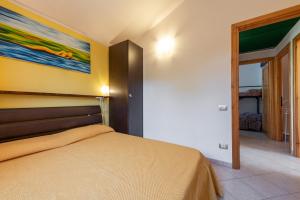 sypialnia z łóżkiem i obrazem na ścianie w obiekcie Domixedda w mieście Costa Rei