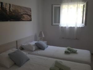 two beds in a white room with a window at Apartments Mate in Split