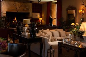 a living room with a couch and a fireplace at A Quinta Da Auga Hotel Spa Relais & Chateaux in Santiago de Compostela
