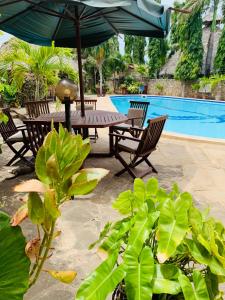 a table and chairs with an umbrella next to a pool at Ltorec in Nyali