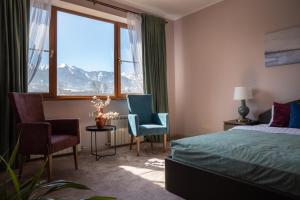 1 dormitorio con 1 cama, 2 sillas y ventana en Mountain view close to Talgar Almaty, en Kaynazarka