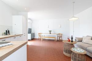 a kitchen and living room with a couch and a table at MY CASA - PONCHETTES 17 - with Garden, 30m from the sea in Nice