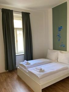 a bedroom with a white bed with a window at Erbenova Apartments in Prague