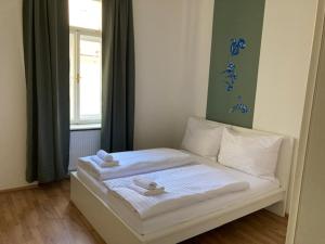 Una cama blanca con toallas en una habitación en Erbenova Apartments, en Praga