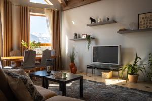 un salon avec une télévision et une table dans l'établissement Mountain view close to Talgar Almaty, à Kaynazarka