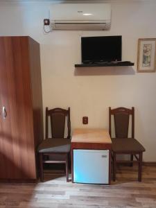 una camera con due sedie, un tavolo e una TV di Mario Complex a Melnik