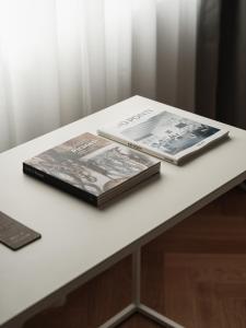 Deux livres sont assis sur une table blanche dans l'établissement Hotel Morfeo, à Milan
