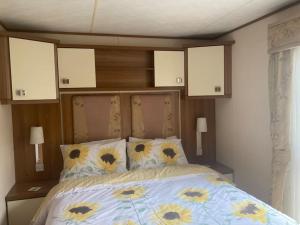 a bedroom with a bed with flowers on it at 2 bedroom chalet in Chwilog on the Llyn Peninsula in Pwllheli