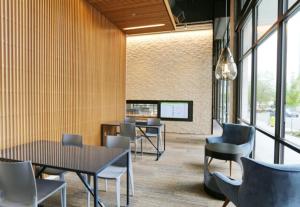 ein Esszimmer mit Tischen und Stühlen und Fenstern in der Unterkunft Downtown Bellevue 1BR w Lounge Gyms nr shops SEA-125 in Bellevue