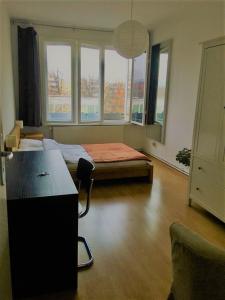 Zimmer mit einem Schreibtisch und einem Bett mit Fenstern in der Unterkunft Private room in the centre of Berlin in Berlin