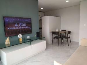 a dining room with a tv and a table with chairs at Jardins da Madalena in Recife