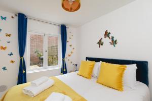 ロンドンにある2 bed 2 bath APT Central Londonのベッドルーム1室(黄色と白の枕付きのベッド1台付)