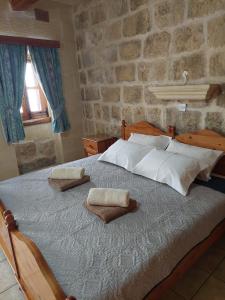 a bedroom with a bed with two pillows on it at MJ Farmhouse B&B in Xagħra