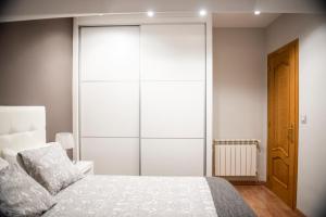 sypialnia z białym łóżkiem i dużą szafą w obiekcie Apartamento Cuatro Caminos w mieście Chantada +34 zdjęcia