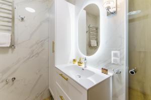 a white bathroom with a sink and a shower at Aquabaltic Apartments Aquarius II in Kołobrzeg