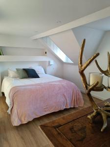 1 dormitorio con 1 cama en una habitación con pendiente en Ô Colombages, en Les Biolles